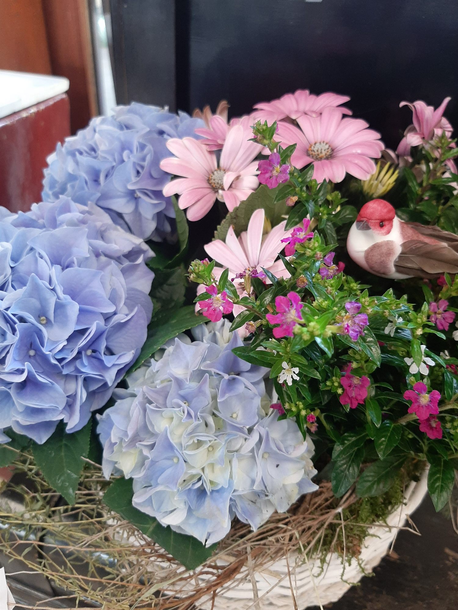 Gesteck aus blauen und rosafarbenen Hortensien in einer Schale