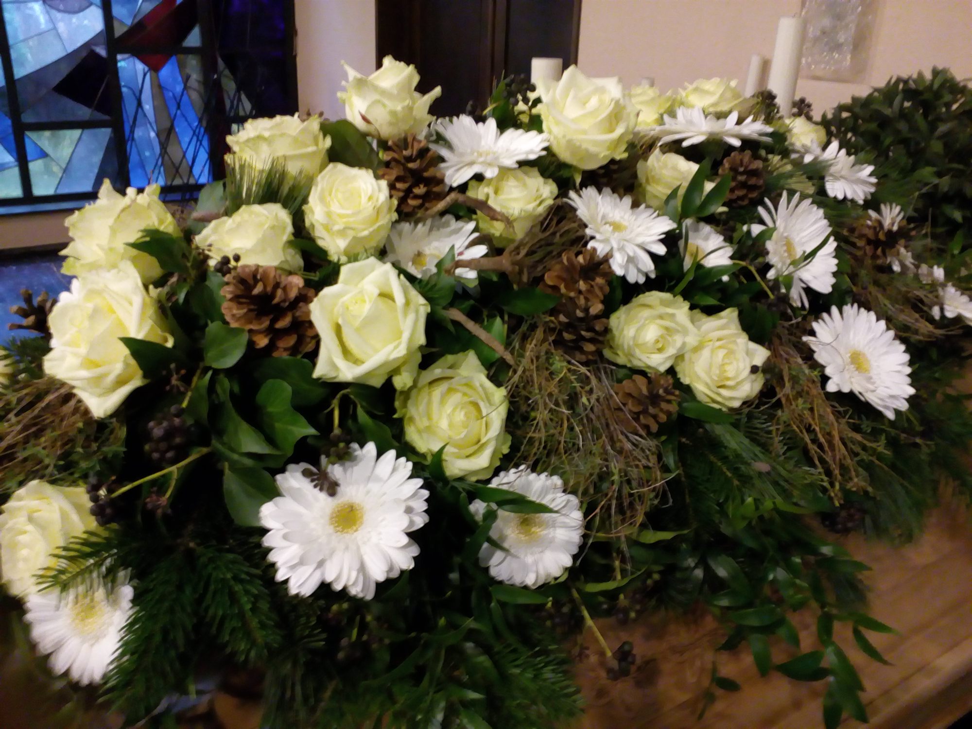 Liegendes Trauergesteck aus weißen Rosen, Chrysanthemen und Tannengrün